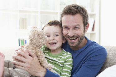 Deutschland, Bayern, München, Vater und Sohn (2-3 Jahre) mit Teddybär, Portrait, lächelnd - RBF000341