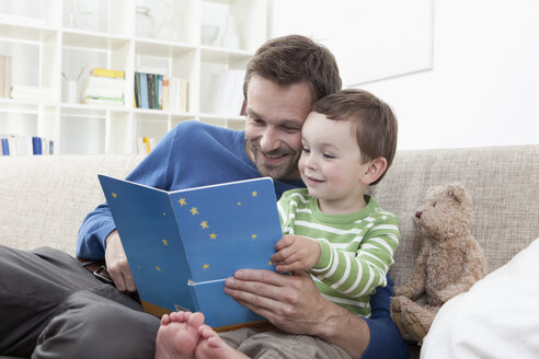 Deutschland, Bayern, München, Vater und Junge (2-3 Jahre) lesen ein Buch - RBF000414