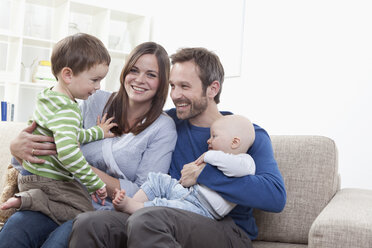 Deutschland, Bayern, München, Familie hat Spaß im Wohnzimmer, lächelnd - RBF000347