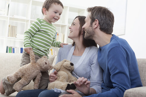 Deutschland, Bayern, München, Familie spielt zusammen im Wohnzimmer - RBF000355