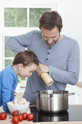 Germany, Bavaria, Munich, Father and son (2-3 Years) preparing meal in kitchen - RBF000369