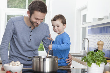 Germany, Bavaria, Munich, Father and son (2-3 Years) preparing meal in kitchen - RBF000373