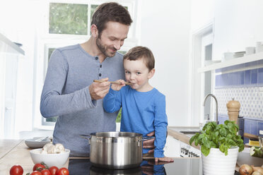 Germany, Bavaria, Munich, Father feeding meal to son (2-3 Years) - RBF000374