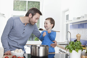 Germany, Bavaria, Munich, Son (2-3 Years) feeding meal to father - RBF000375