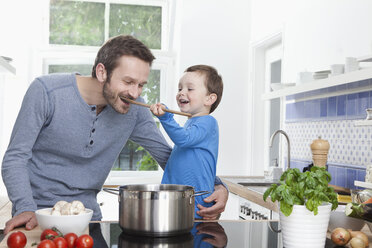 Germany, Bavaria, Munich, Son (2-3 Years) feeding meal to father - RBF000376