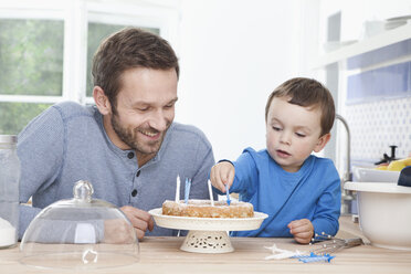 Germany, Bavaria, Munich, Father and son (2-3 Years) preparing birthday cake - RBF000380