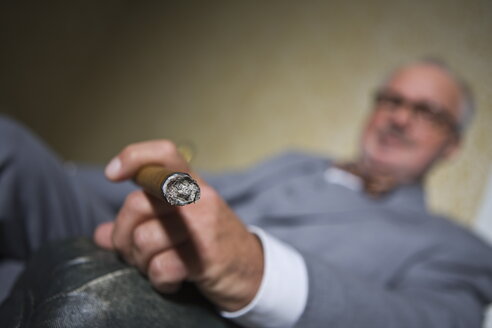 Germany, Braunschweig, Senior man smoking cigar, close up - HKF000359