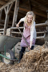 Deutschland, Sachsen, Junge Frau arbeitet auf dem Bauernhof - MBF001028