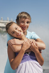 Germany, Munich, Karlsplatz, Young man embracing woman smiling, portrait - RNF000415