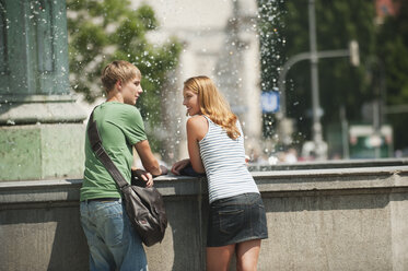 Germany, Munich, Young man and young woman at fountain in university - RNF000387