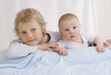 Deutschland, Junge (2-3 Jahre) und kleiner Junge (2-5 Monate) auf dem Bett liegend - WBF000445