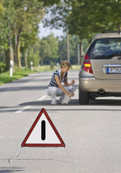 Germany, Augsburg, Young woman repairing puncture - WBF000033