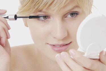 Young woman applying mascara, close up - WBF000469
