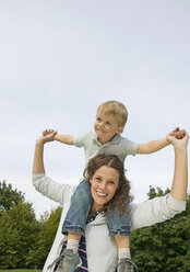 Mother carrying son on shoulders, smiling - WBF000502