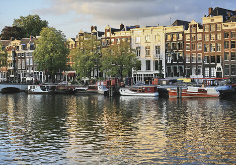 Niederlande, Amsterdam, Blick auf Häuser und Boot mit Amstelkanal - WBF000222