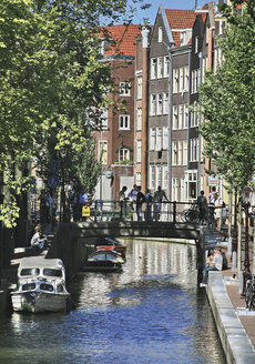 Niederlande, Amsterdam, Menschen auf kleiner Brücke über den Kanal - WBF000223
