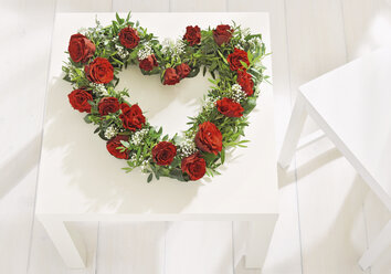 Herzförmiger Blumenkranz auf dem Tisch zum Muttertag - WBF000242