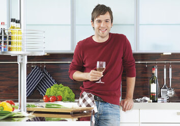 Deutschland, Junger Mann mit Weinglas in der Küche - WBF000604