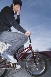 Germany, Stuttgart, Young man on red BMX bike - WBF000639