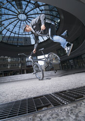 Deutschland, Stuttgart, Junger Mann beim Stunt auf dem Fahrrad - WBF000641
