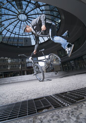 Germany, Stuttgart, Young man performing stunt on bike - WBF000641