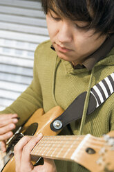 Germany, Augsburg, Young man playing an electric guitar - WBF000645