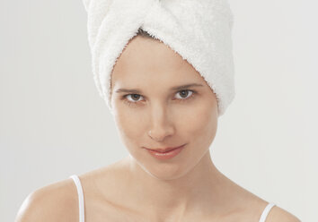 Young woman with towel wrapped around hair, portrait - WBF000700