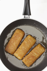 Fish fingers frying in a pan, close up - THF001134