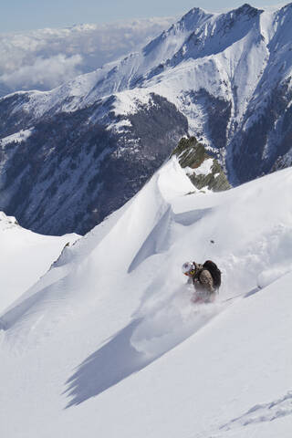 Österreich, Kaprun, Kitzsteinhorn, Mann beim Skifahren im Pulverschnee, lizenzfreies Stockfoto