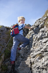 Germany, Bavaria, Boy (4-5 Years) climbing mountain, smiling, portrait - HSIF000026