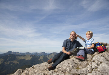 Deutschland, Bayern, Vater und Sohn (4-5 Jahre) schauen mit Karte auf Berggipfel weg - HSIF000020