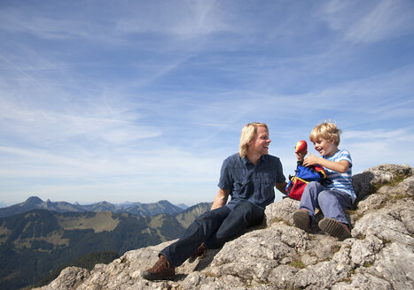 Deutschland, Bayern, Vater und Sohn (4-5 Jahre) schauen mit Karte auf Berggipfel weg - HSIF000019