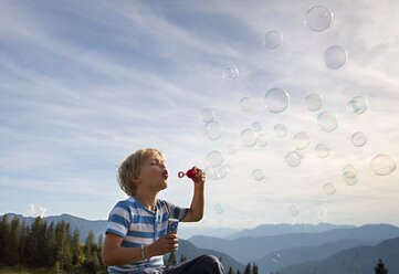 Germany, Bavaria, Boy (4-5 Years) blowing soap bubbles - HSIF000006