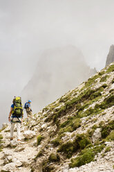 Italy, Dolomites, Mountain hikers hiking on Rosengarten mountains - RNF000576