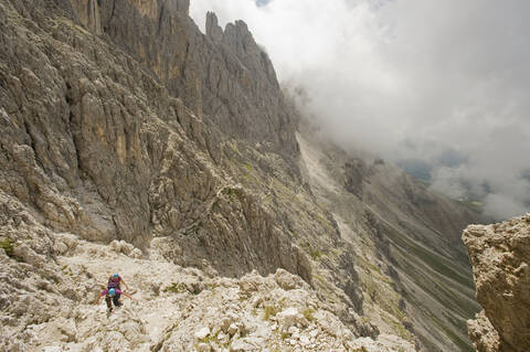 Italy, Dolomites, Mountain hikers hiking at Rosengarten mountains stock photo