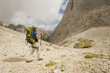 Italien, Dolomiten, Ältere Frau beim Wandern im Rosengarten - RNF000548