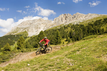 Italien, Dolomiten, Älterer Mann beim Radfahren in den Latemarbergen - RNF000578