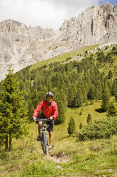 Italien, Dolomiten, Älterer Mann beim Radfahren in den Latemarbergen - RNF000579