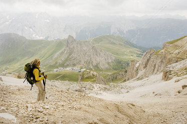 Italien, Dolomiten, Ältere Frau beim Wandern am Pordoi - RNF000555