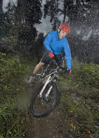 Deutschland, Bayern, Mann fährt Mountainbike auf Feldweg, lizenzfreies Stockfoto