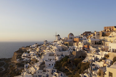 Griechenland, Kykladen, Thira, Santorin, Oia, Blick auf Windmühle und Dorf bei Sonnenuntergang - FOF002689