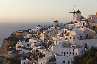 Griechenland, Kykladen, Thira, Santorin, Oia, Blick auf Windmühle und Dorf bei Sonnenuntergang - FOF002691