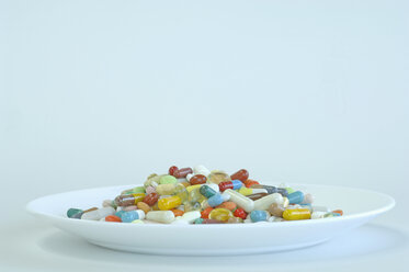 Verschiedene Pillen in einem Teller auf farbigem Hintergrund - ASF004208