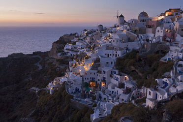 Griechenland, Kykladen, Thira, Santorin, Blick auf Oia und Windmühlen nach Sonnenuntergang - FOF002841