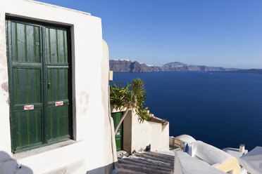 Griechenland, Kykladen, Thira, Santorini, Geschlossene grüne Türen mit dem Ägäischen Meer im Hintergrund - FOF002833