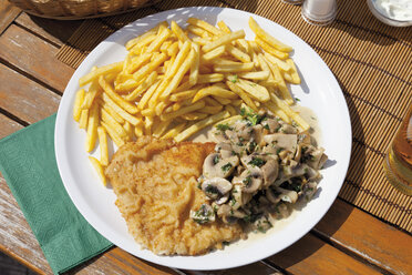 Schnitzel mit Champignons und Pommes frites im Teller - CSF013722