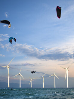 Kroatien, Zadar, Kitesurfer springt vor einer Windkraftanlage - HSIF000059