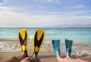 Croatia, Zadar, Couple with flippers relaxing on beach - HSIF000037