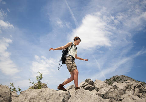 Kroatien, Zadar, Junge Frau balanciert über Felsen, lizenzfreies Stockfoto