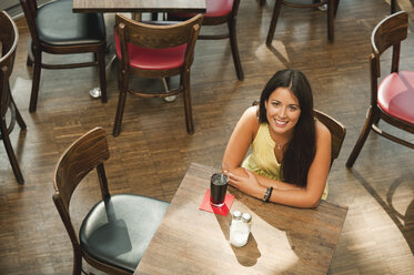 Germany, Munich, Young woman in cafe, smiling, portrait - RNF000538